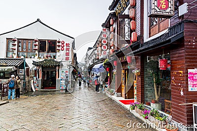 Street view with wooden historic buildings in Zhujiajiao in a rainy day, an ancient water town in Shanghai, built during Ming and Editorial Stock Photo