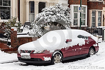 Street winter cityscape with snow covered frozen car Editorial Stock Photo