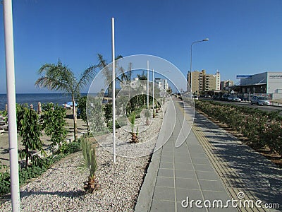 Streets of Lannaka on the island of Cyprus. Tourist area near the Mediterranean, cafes, hotels, the alley of palm trees. Stock Photo