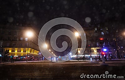 Streets of Paris during snowfall at winter night Stock Photo