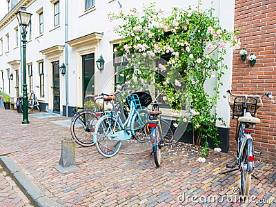 Streetscene in old town of Wijk bij Duurstede with parked bicycles and climbing rose, Netherlands Editorial Stock Photo