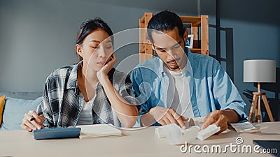 Stress asia couple man and woman use calculator for calculate family budget, debts, monthly expenses during financial economic Stock Photo