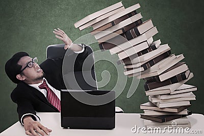 Stress businessman with falling books and copyspace Stock Photo