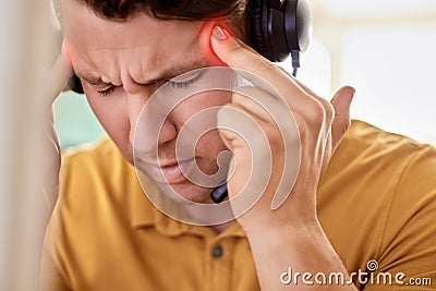 Stress, call center and man with headache, burnout and overworked with pain, overtime and exhausted. Male employee Stock Photo