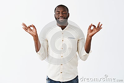 Stress floats away with every minute during meditation. Happy relieved dark-skinned calm man with beard in casual outfit Stock Photo