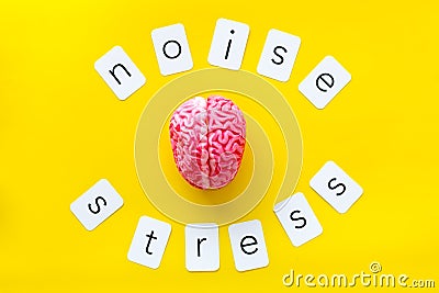 Stress and noise text with brain for psychological health in office concept on yellow background top view Stock Photo