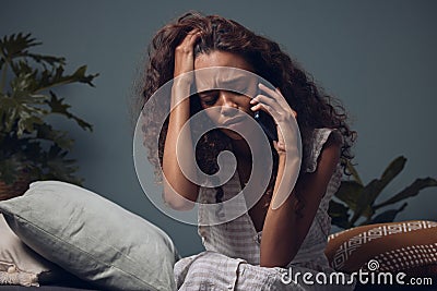 Stress, phone call and woman on sofa with crying for break up, grief and loss in home. Mental health, divorce and girl Stock Photo