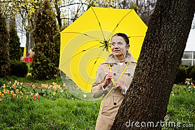 Stress resilience and mental health, concept. Managing stress and building resilience. Happy senior woman in yellow rain Stock Photo