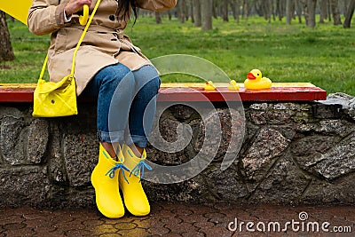 Stress resilience and mental health, no depression concept. Womens legs in yellow rubber boots and a yellow rubber duck Stock Photo