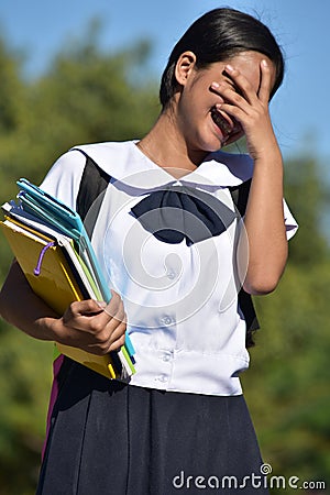 Stressed Or Ashamed Female Student Holding Books Stock Photo