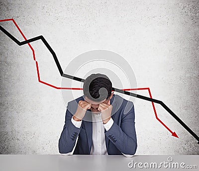 Stressed Asian businessman and declining graphs Stock Photo