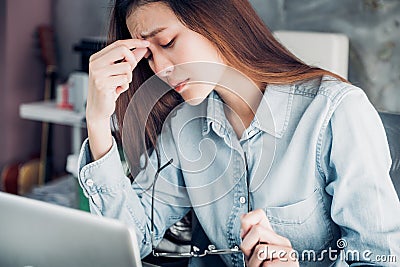 Stressed Asian creative designer woman cover her face with hand Stock Photo