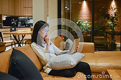 Stressed Asian woman using laptop at night, freelance working la Stock Photo