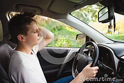 Stressed and bewildered driver, pissed off keeps hands to head, has traffic problems. Unlucky man has a road accident Stock Photo