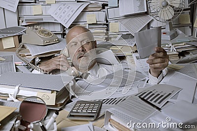 Stressed businessman overwhelmed by work Stock Photo
