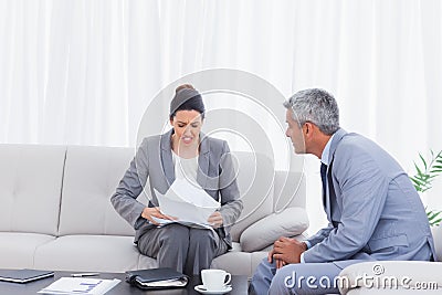 Stressed businesswoman holding documents and businessman trying Stock Photo