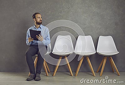 Stressed caucasian man feeling fear before job interview sitting on chair Stock Photo