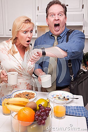Stressed Couple in Kitchen Late for Work Stock Photo