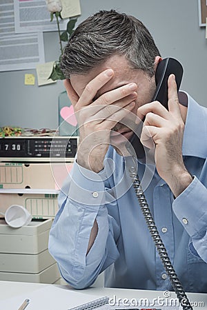 Stressed employee on the phone Stock Photo