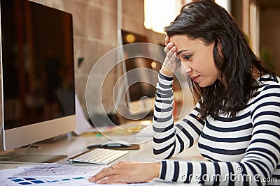 Stressed Female Designer Works At Computer In Modern Office Stock Photo