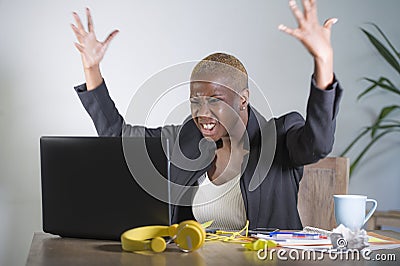 Stressed and frustrated afro American black woman working overwhelmed and upset at office laptop computer desk gesturing angry in Stock Photo