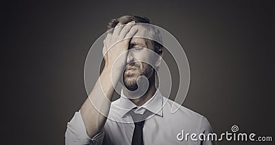 Stressed frustrated businessman making a facepalm gesture Stock Photo