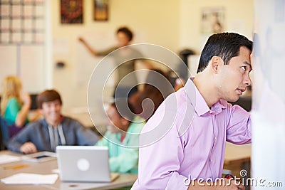 Stressed High School Teacher Trying To Control Class Stock Photo