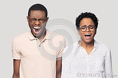 Stressed mad millennial ethnic family couple feeling angry, screaming. Stock Photo