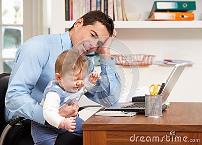 Stressed Man With Baby Working From Home Stock Photo