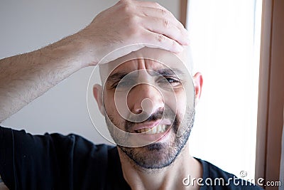 Stressed man. Frustrated young man touching his head with his hand. Headache concept. Stress concept Stock Photo