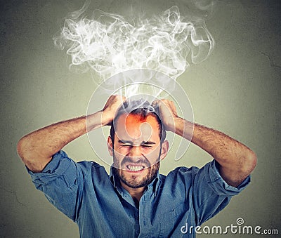 Stressed man having headache steam coming up Stock Photo