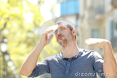 Stressed man sweating suffering heat stroke a warm day Stock Photo