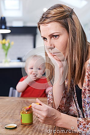Stressed Mother Trying To Feed Fussy Baby Stock Photo