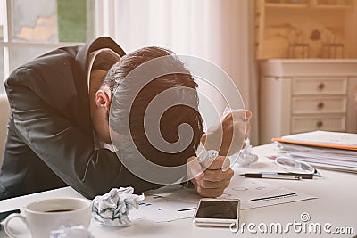 A stressed out business man holds his head in despair Stock Photo