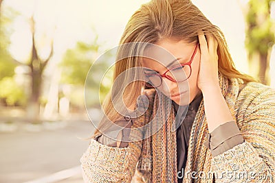 Stressed sad woman sitting outdoors. City urban life style stress Stock Photo