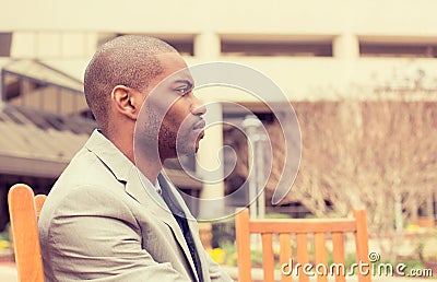 Stressed unhappy businessman sitting outside corporate office Stock Photo