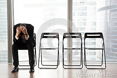 Stressed upset businessman sitting on chair, received bad news. Stock Photo