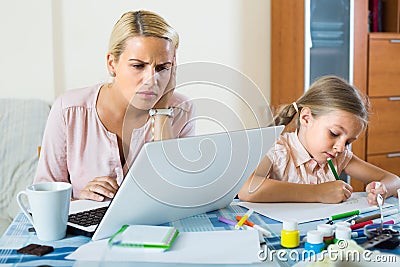 Stressed woman with child working from home Stock Photo