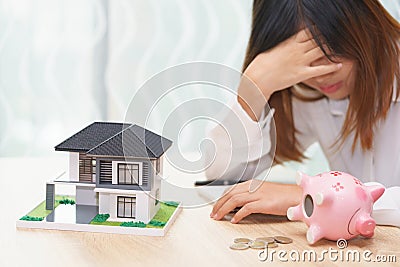 Stressed woman with running out of money in piggy bank and her h Stock Photo