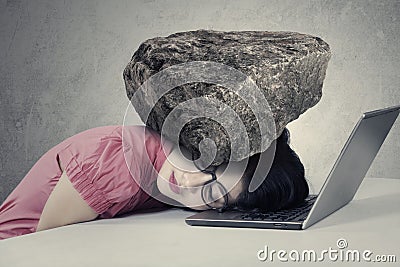 Stressed worker with a burden on her head Stock Photo