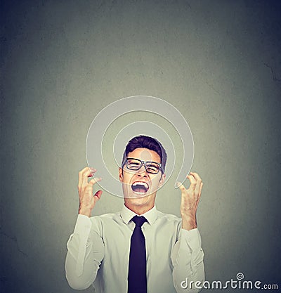 Stressed young business man in glasses screaming in desperation Stock Photo