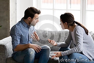 Stressed young married family couple arguing, blaming each other. Stock Photo