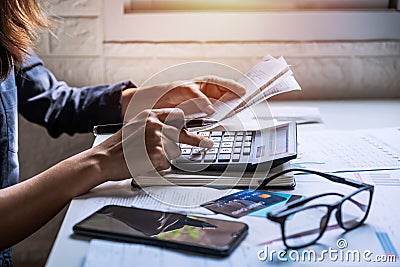 Stressed young woman checking bills, taxes and calculating expenses in the living room at home Stock Photo