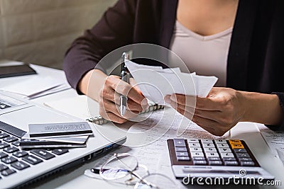 Stressed young woman checking bills, taxes, bank account balance and calculating expenses in the living room Stock Photo