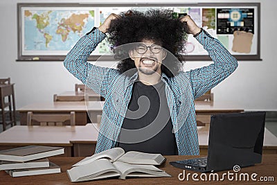 Stressful student pulling his hair in class Stock Photo