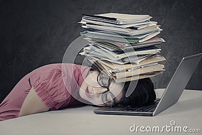 Stressful woman with paperwork on her head Stock Photo