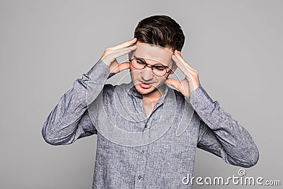 Stressful young man feels terrible headache, being frustrated and depressed, clenches teeth in pain, suffers from ache, closes Stock Photo