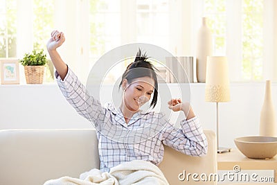 Stretching young woman wearing pyjama Stock Photo