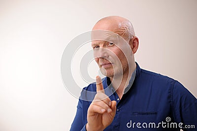 Strict boss Attention Emotions of an adult handsome bald man A man on a white background in a blue shirt family rules Stock Photo