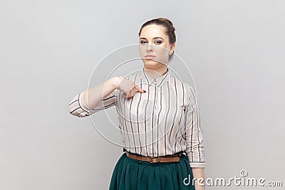 Strict bossy serious woman standing pointing at herself with proud expression, looks arrogant. Stock Photo